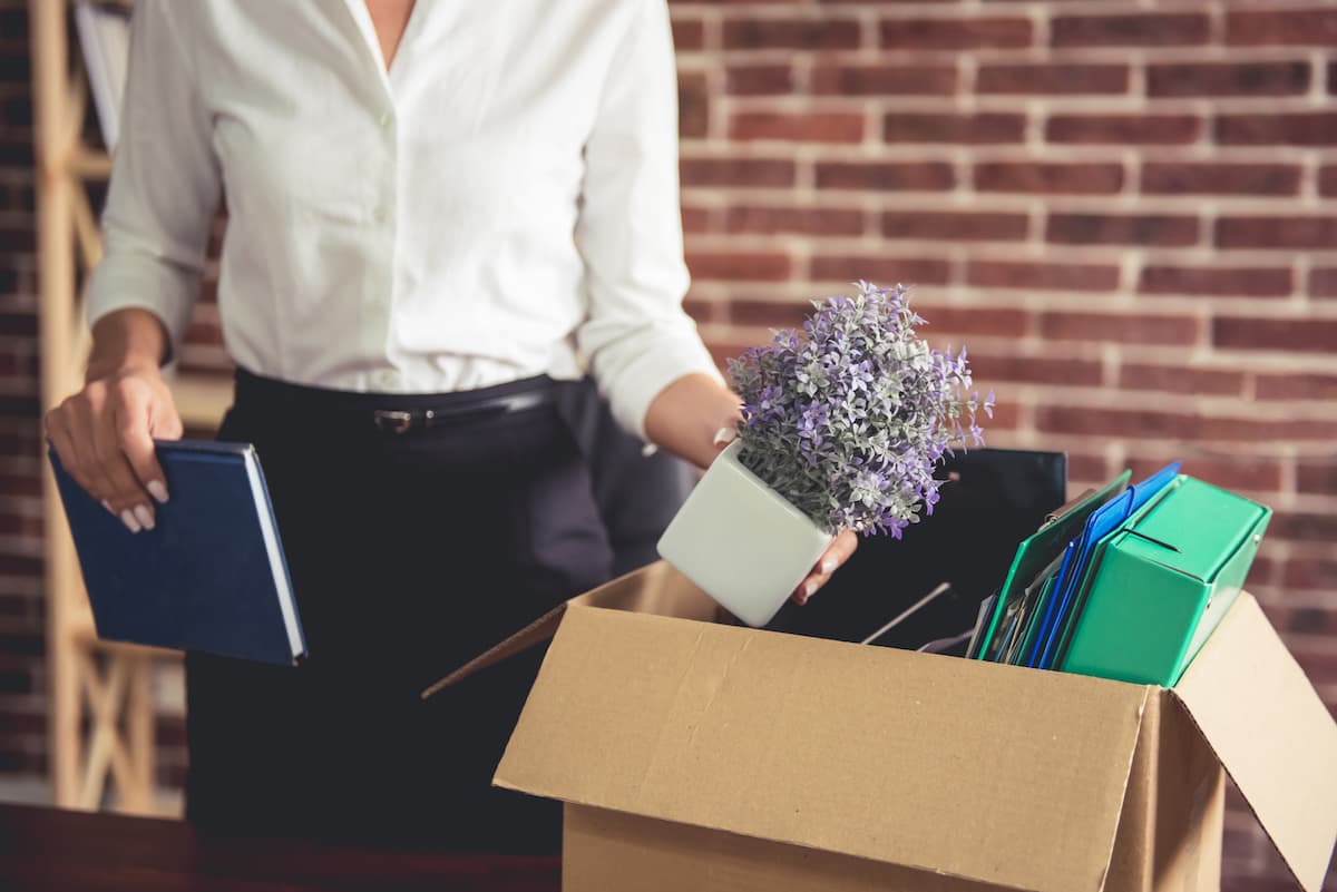 businesswoman holding a packed box full of office things